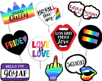 May include: A set of 10 rainbow-themed photo booth props with various phrases and images, including "yaaas queen", "love wins", "pride", "love is love", "born this way", "less hate more love", "hello I'm gay af", "squad", and a rainbow middle finger.