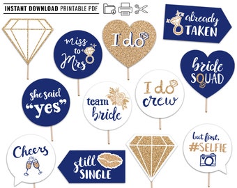 May include: A set of 10 printable bridal shower photo booth props featuring gold glitter and navy blue accents. The props include phrases like "She said yes", "Miss to Mrs", "I do crew", "Bride Squad", "Team Bride", "Still Single", "But first, #Selfie", "Cheers", "Already Taken", and "I do".