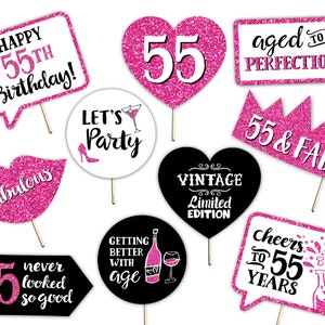 May include: Pink and black photo booth props with glitter and text for a 55th birthday party. The props include a heart with the number 55, a crown with the text "55 & FAB", a speech bubble with the text "Happy 55th Birthday!" and a speech bubble with the text "Cheers to 55 Years".