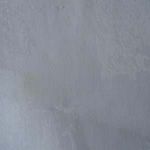 May include: A white linen tablecloth with a subtle embossed pattern. The tablecloth has a small brown stain.
