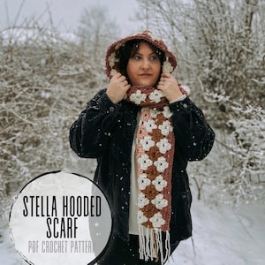 May include: A hooded scarf with a floral pattern in shades of brown, cream, and pink. The scarf has a fringe at the bottom and is worn with a black jacket. The text "STELLA HOODED SCARF PDF CROCHET PATTERN" is in a circle.