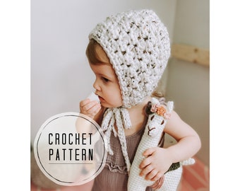 May include: A white crocheted baby bonnet with a tied bow. The bonnet is worn by a child holding a crocheted llama toy with a flower crown.