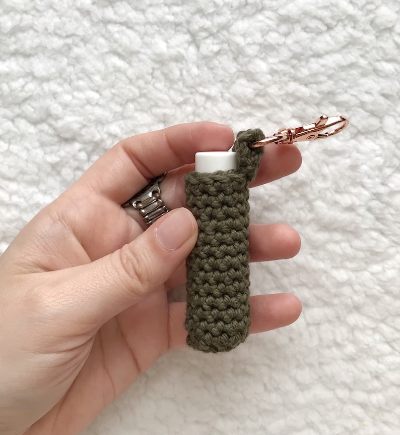 Pu&ograve; includere: Un porta-balsamo per labbra in crochet verde con un portachiavi in oro rosa. Il porta-balsamo &egrave; realizzato con una maglia testurizzata ed &egrave; progettato per adattarsi a un tubo di balsamo per labbra di dimensioni standard.