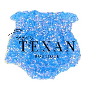 May include: A light blue baby onesie with iridescent sequins. The onesie has a ruffled neckline and is made of a soft, stretchy fabric. The text "Teeny Texan Boutique" is printed on the front of the onesie.