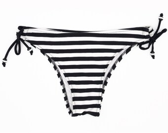 Zwart-wit gestreept bikinibroekje. Striksluiting aan de zijkant met zwart-wit gestreepte kralen.