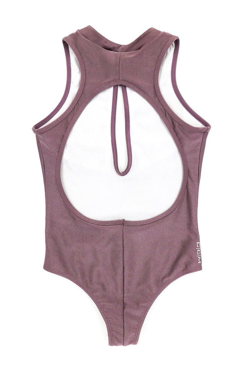 size small lilac bodysuit showing off the back with high crew neckline, large eyelet, sleeveless, open back, can be worn as a bodysuit, one piece swimsuit, and gym suit