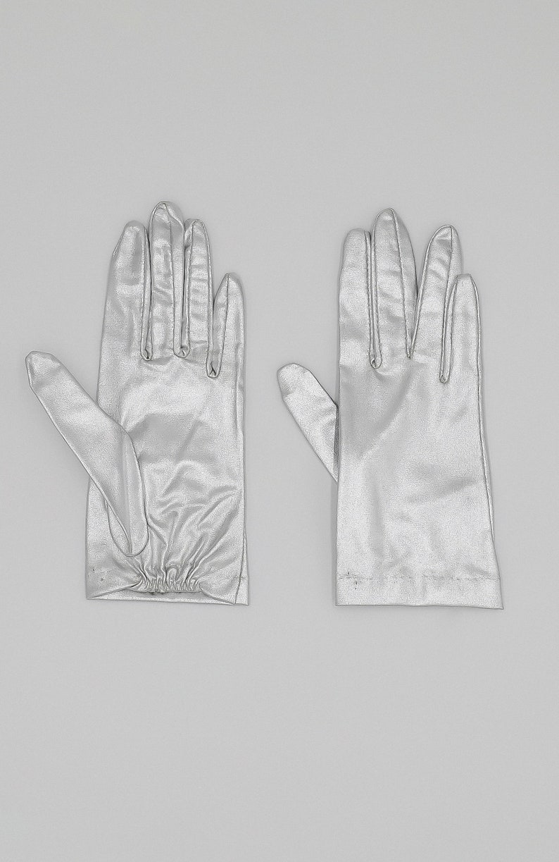 collector of vision deadstock metallic silver gloves in a size XS. Elastic pleated detail on the bottom of the wrist area. An elegant glove that would be perfect for your wedding.