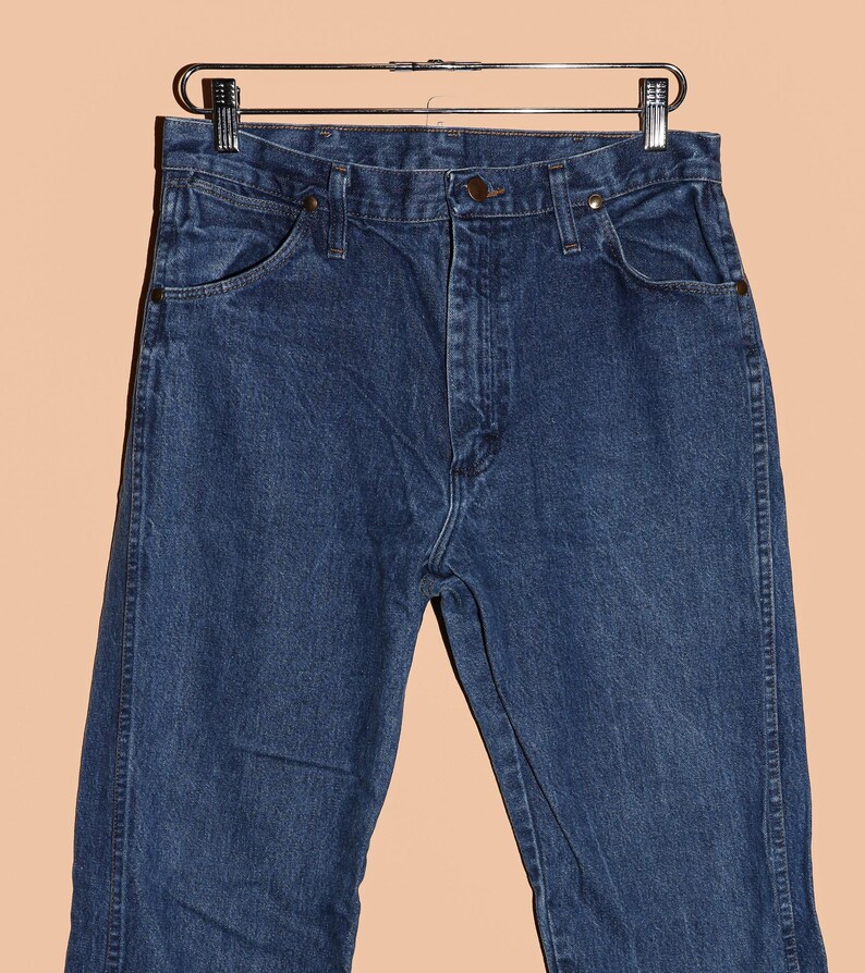 K&ouml;nnte beinhalten: Eine dunkelblaue Jeanshose im klassischen 5-Pocket-Stil. Die Jeans hat einen geraden Schnitt und einen Knopfverschluss.