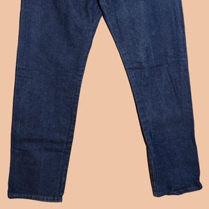 May include: A pair of dark blue denim jeans with a straight leg fit.
