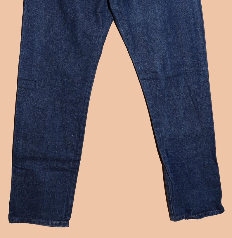 May include: A pair of dark blue denim jeans with a straight leg fit.