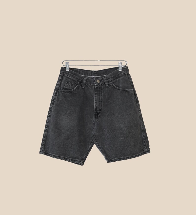 May include: Black denim shorts with a button and zipper closure. The shorts have five pockets and a relaxed fit.
