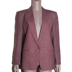 May include: A dusty rose blazer with a single-button closure. The blazer has a notched lapel, two front pockets, and long sleeves. The fabric has a subtle textured appearance. The blazer is displayed on a mannequin.