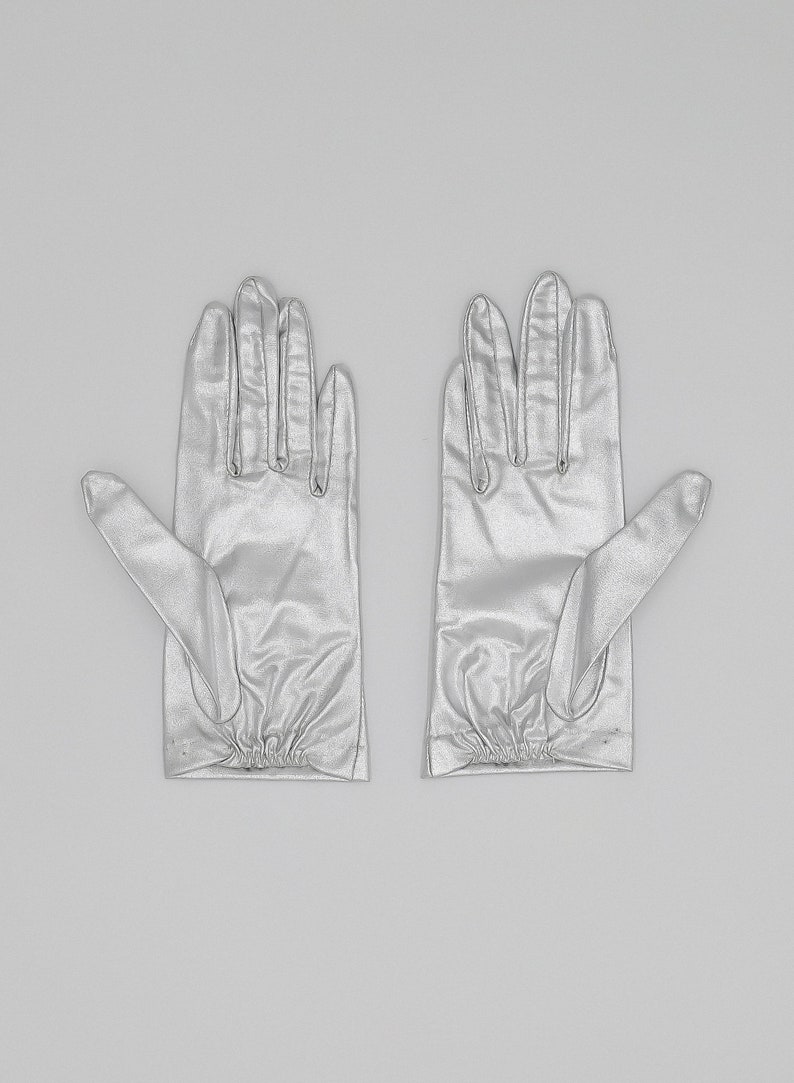 collector of vision deadstock metallic silver gloves in a size XS. Elastic pleated detail on the bottom of the wrist area. An elegant glove that would be perfect for your wedding.