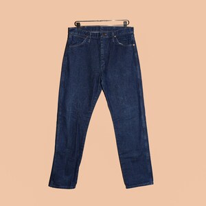 May include: A pair of dark blue denim jeans with a button fly and belt loops.