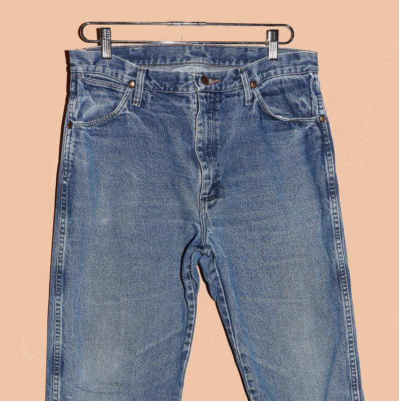May include: A pair of light blue denim jeans with a classic straight leg fit. The jeans have a faded look and are made of a soft, comfortable cotton blend.