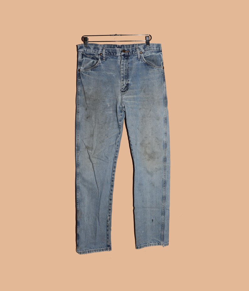 May include: A pair of light blue denim jeans with a faded look. The jeans have a straight leg and a classic five-pocket style.