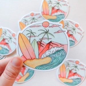 May include: A set of colorful stickers featuring a beach scene with palm trees, a wave, and surfboards. The stickers are round and have a white background.