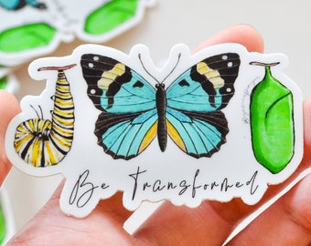 May include: A white sticker with a blue butterfly, a green cocoon, and a yellow and black caterpillar. The sticker says "Be Transformed".