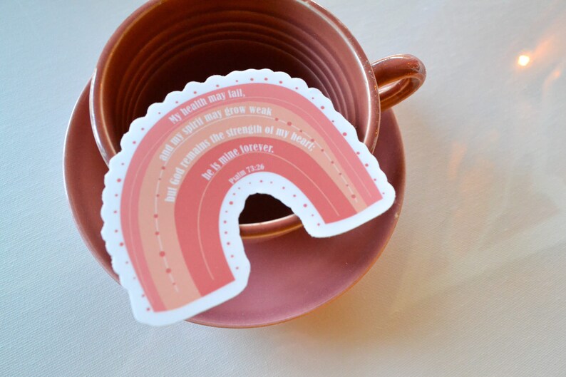 May include: A pink and orange rainbow sticker with the text "My health may fail, and my spirit may grow weak, but God remains the strength of my heart; He is mine forever. Psalm 73:26"