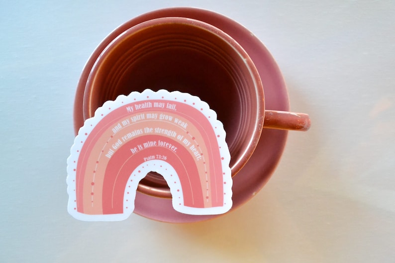 May include: A pink and orange rainbow sticker with the text "My health may fail, and my spirit may grow weak, but God remains the strength of my heart: he is mine forever. Psalm 73:26"