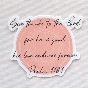 May include: A pink and white sticker with a circle design and the text "Give thanks to the Lord. for he is good. his love endures forever. Psalm 118.1"
