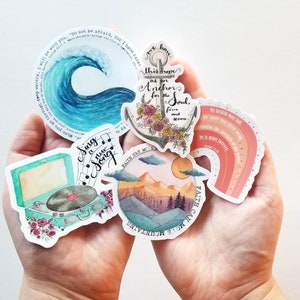 May include: A set of five stickers featuring watercolor illustrations with inspirational quotes. The stickers include a wave with the quote "Do not be afraid, for I have ransomed you", an anchor with the quote "We have this hope as our anchor for the soul, firm and secure", a record player with the quote "Sing a new song", a mountain range with the quote "Faith can move mountains", and a rainbow with the quote "My health may fail, my spirit may grow weak, remains the strength of my heart: he is mine forever."
