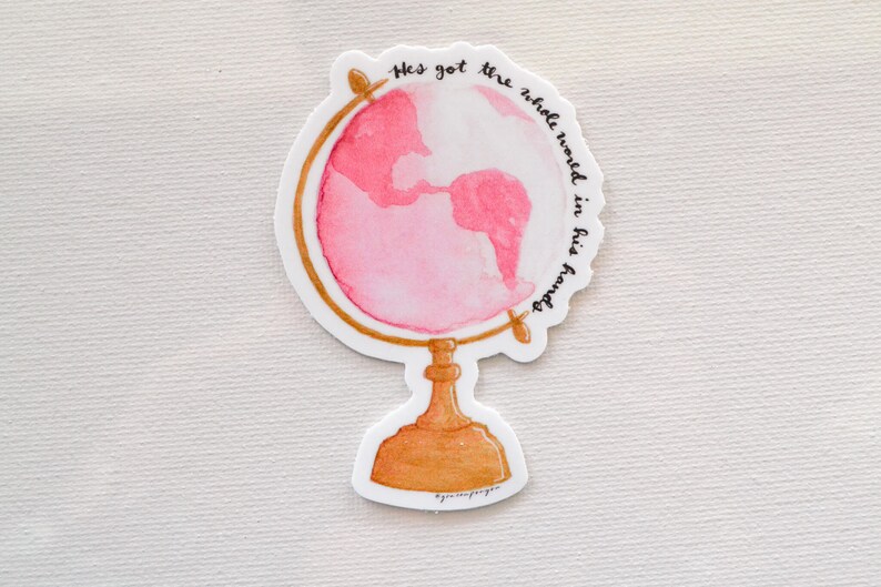 May include: A pink watercolor globe with a gold stand and the text "He's got the whole world in his hands".