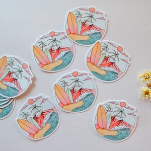 May include: A set of nine round stickers featuring a colorful illustration of a beach scene with palm trees, a surfboard, and a wave. The stickers are perfect for adding a touch of summer to your laptop, water bottle, or planner.
