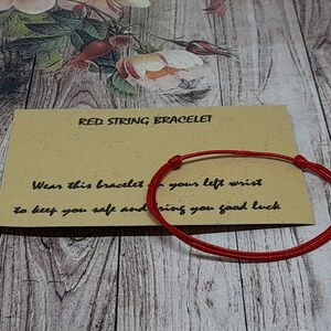 Peut inclure: Bracelet en cordon rouge avec une note qui dit "Portez ce bracelet à votre poignet gauche pour vous garder en sécurité et vous porter bonheur."