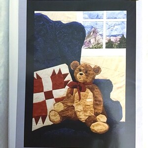 May include: A quilting pattern for a teddy bear sitting on a chair with a window behind it. The pattern includes iron-on templates. The pattern is from England Design Studios, 803 Voyager, Houston, TX 77062, (281) 488-3936.