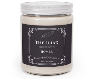May include: A white candle jar with a black label that reads "THE ILIAD" with a decorative feather design and the text "HOMER" and "Classic Book Collection" in white. The label also includes the text "Books & Bards".