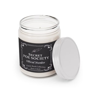 May include: A white candle in a glass jar with a black label that reads "Secret Poe Society Official Member Classic Book Collection Books & Barrels". The jar has a silver lid.