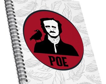 May include: A white spiral notebook with a red circle featuring a black and white illustration of Edgar Allan Poe with a raven on his shoulder. The text "POE" is written in black below the illustration. The background of the notebook is a white pattern of feathers.