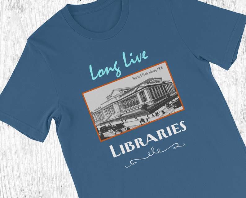 K&ouml;nnte beinhalten: Ein blaues T-Shirt mit einem Vintage-Bild der New York Public Library und dem Text "Long Live Libraries" in einer kursivschrift.