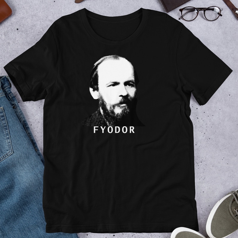 K&ouml;nnte beinhalten: Schwarzes T-Shirt mit einem wei&szlig;en Bild von Fjodor Dostojewski, einem russischen Schriftsteller, und dem Wort "FYODOR" darunter.