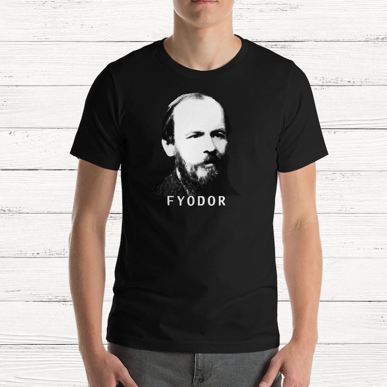 K&ouml;nnte beinhalten: Schwarzes T-Shirt mit einem wei&szlig;en Bild von Fjodor Dostojewski, einem russischen Schriftsteller, und dem Wort "FYODOR" unter dem Bild.