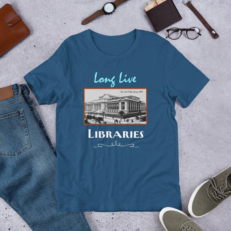 K&ouml;nnte beinhalten: Ein blaues T-Shirt mit einem Vintage-Bild der New York Public Library und dem Text "Long Live Libraries" darauf.