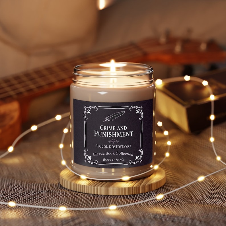 May include: A brown glass candle with a black label that reads "Crime and Punishment" by Fyodor Dostoevsky. The label also says "Classic Book Collection" and "Books & Barks". The candle is lit and sitting on a wooden coaster.