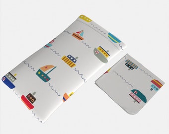 May include: A white glasses case with a blue, red, yellow, and green boat pattern. The case is closed and has a white microfiber cleaning cloth next to it.