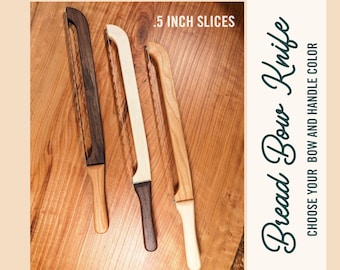 May include: Three wooden bread knives with different colored handles. The knives are on a wooden surface. The text on the image reads "Bread Bow Knife" and "Choose your bow and handle color" and ".5 inch slices".