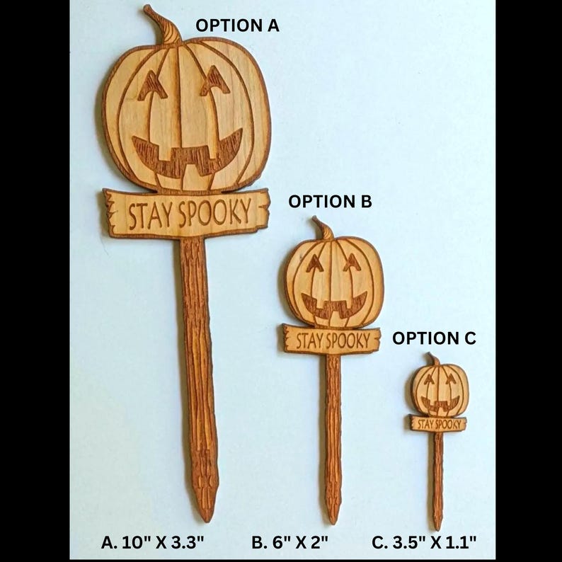 May include: Three wooden pumpkin stake decorations with the text "Stay Spooky" on a sign. The stakes are available in three sizes: 10 inches by 3.3 inches, 6 inches by 2 inches, and 3.5 inches by 1.1 inches.