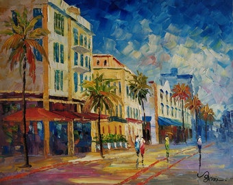 May include: A colorful oil painting depicting a street scene with palm trees, buildings, and people walking. The buildings are painted in shades of yellow and white, with red awnings over the storefronts. The sky is a vibrant blue with white clouds.
