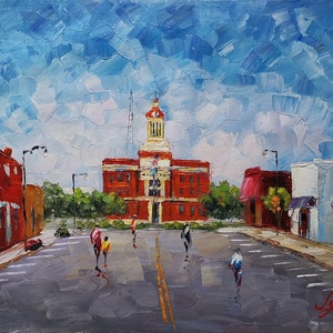 May include: A painting of a small town with a red brick building in the center. The building has a clock tower and a flag flying from the top. There are people walking on the street in front of the building. The sky is blue with white clouds.