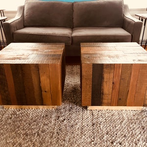 May include: Two wooden coffee tables with a rustic, reclaimed wood design. The tables are made of various shades of brown wood and have a natural, unfinished look.