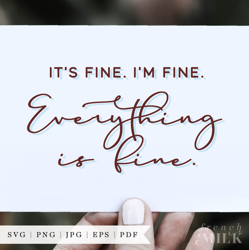 May include: A white card with the text "IT'S FINE. I'M FINE. Everything is fine." written in brown cursive script. The card is being held by a hand with white nail polish.