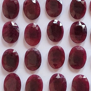 Puede incluir: Una colecci&oacute;n de 16 piedras preciosas ovaladas de color rojo oscuro. Las piedras preciosas son facetadas y tienen un acabado pulido.