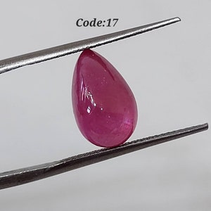 Może przedstawiać: Różowy kamień szlachetny w kształcie gruszki trzymany przez pęsetę. Kod: 17