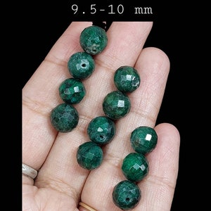 Peut inclure: Un brin de 10 perles de pierres précieuses vertes facettées, chacune mesurant 9,5 à 10 mm de diamètre. Les perles ont une finition lisse et polie et sont enfilées sur un fil transparent.