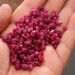 Op de afbeelding: Een handvol kleine, dieprode robijn edelstenen.