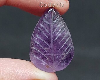May include: A carved amethyst leaf pendant in a purple hue. The leaf has a detailed vein pattern carved into the surface. Code: G